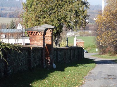 Vlevo vbok a jsme u zadní zdi hřbitova.