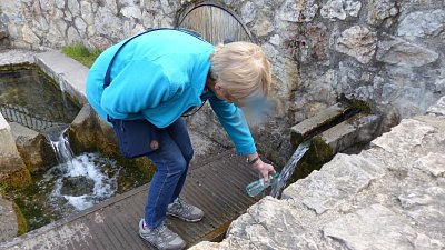 Olinka nabírá vodu z léčivého pramene